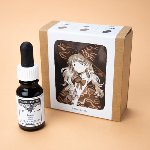 A photo of the Pebble Grays ink set in its box, with one bottle of the color sepia next to it. The label on the box is a painting of a long haired witch wearing a pointy hat and a cloak with a wavy pattern.