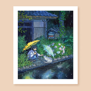 Print of a colored ink artwork depicting a character with a yellow umbrella squatting on the side of the road next to a traditional Japanese house and holding another, transparent umbrella over a grey tabby cat. It's raining and the characters are surrounded by greenery. Behind them there is a small altar with a frog statue.
